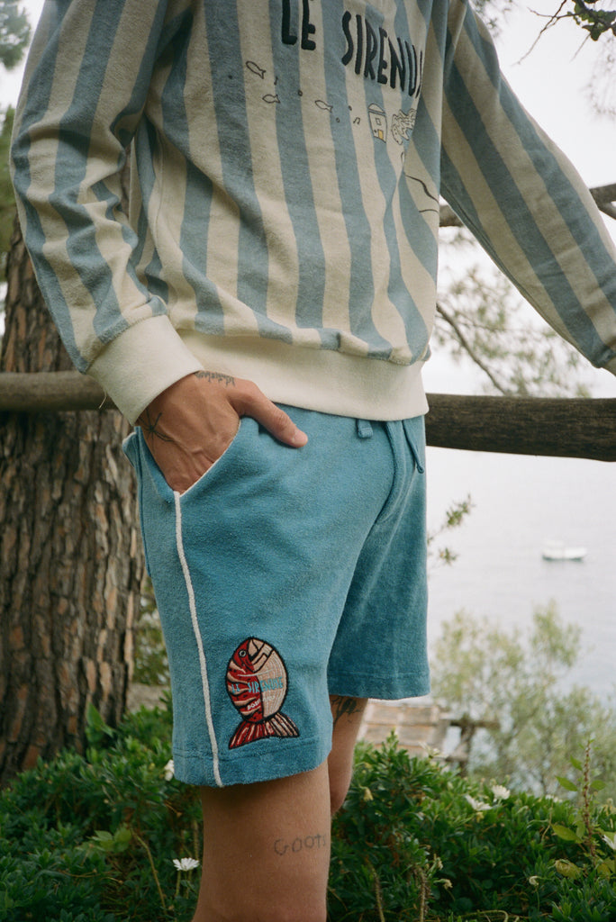 male model in long sleeve le sirenuse tee and pop on shorts with hand in pocket