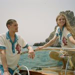 Male and female models on boat both wearing the pop over