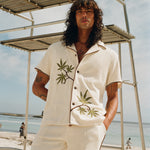 man looks at camera leaning against lifeguard chair