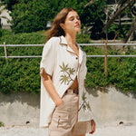 woman puts one hand in pocket and looks away from camera