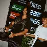 Model wearing big brut shirt popping top off of real champagne bottle