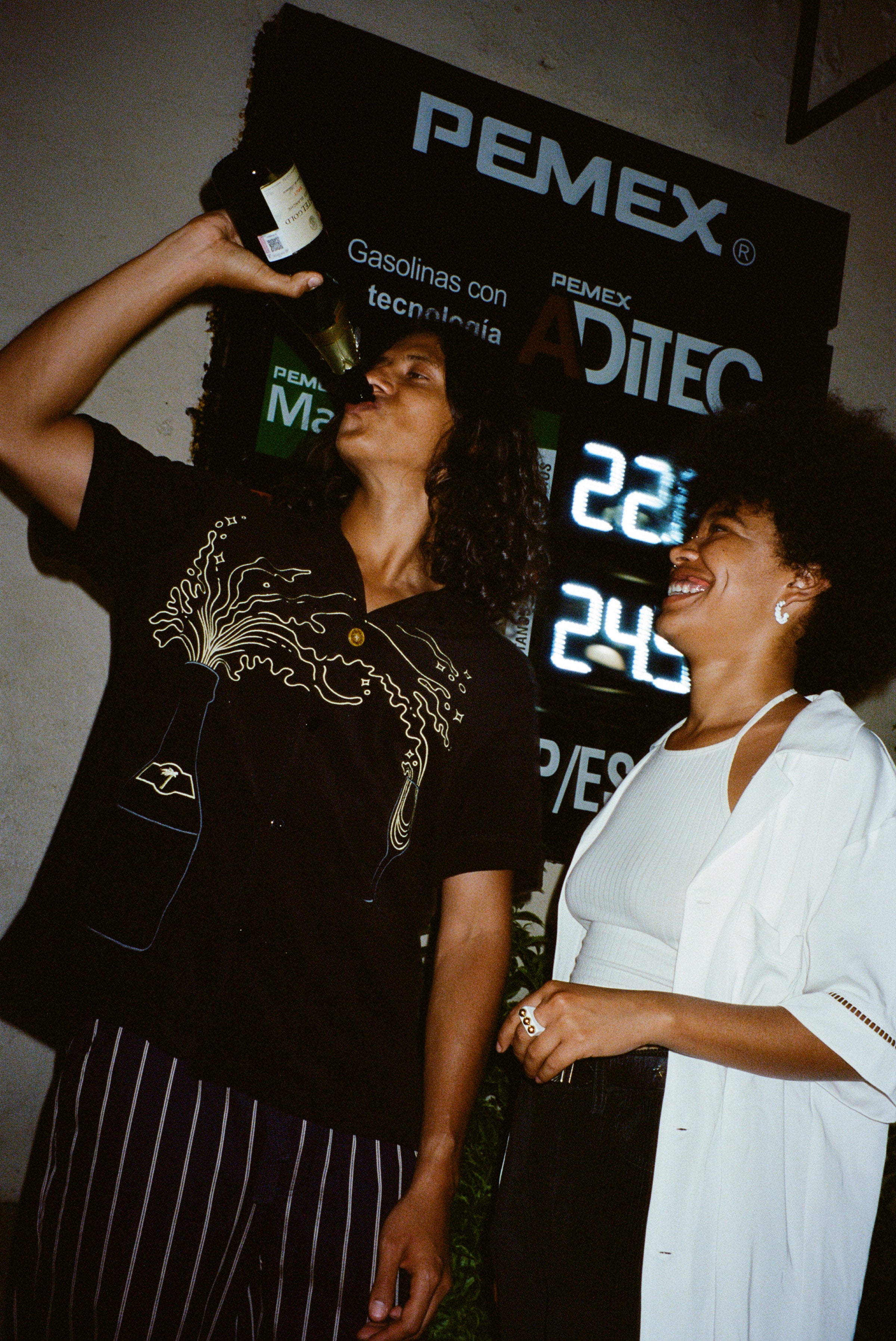 Man wearing Big Brut shirt drinking straight out of champagne bottle