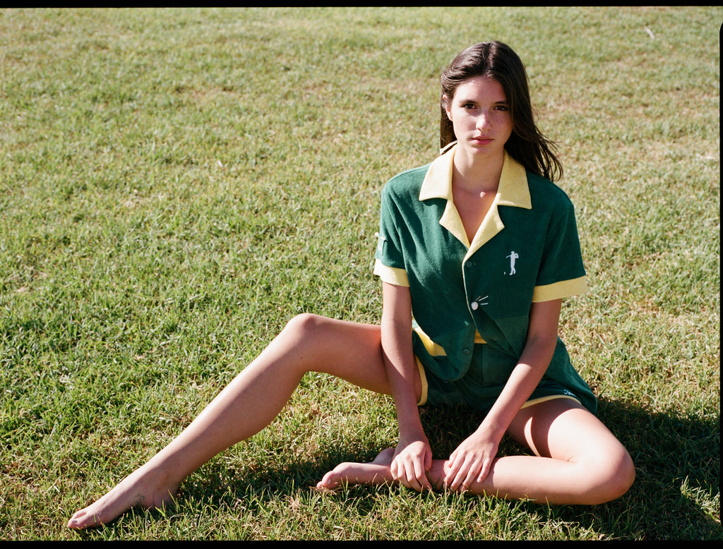 Woman sits in field with full green terrycloth set