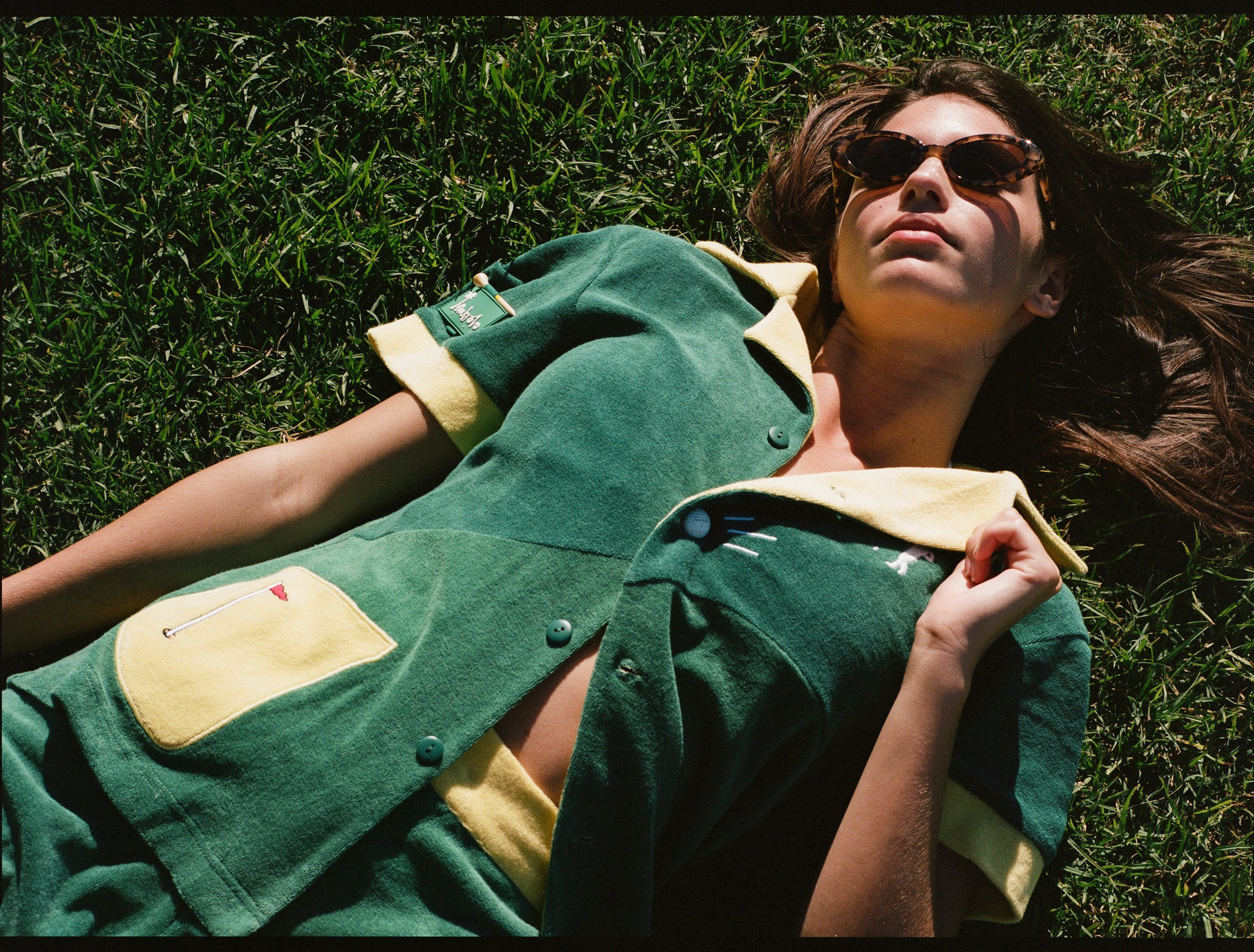 Female model wearing matching set lying down in grass