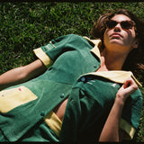 Female model wearing matching set lying down in grass