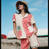 Female model standing wearing the full terry cloth Gusanito set along with a woven sun hat and sunglasses
