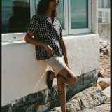 man leans against wall with one foot up