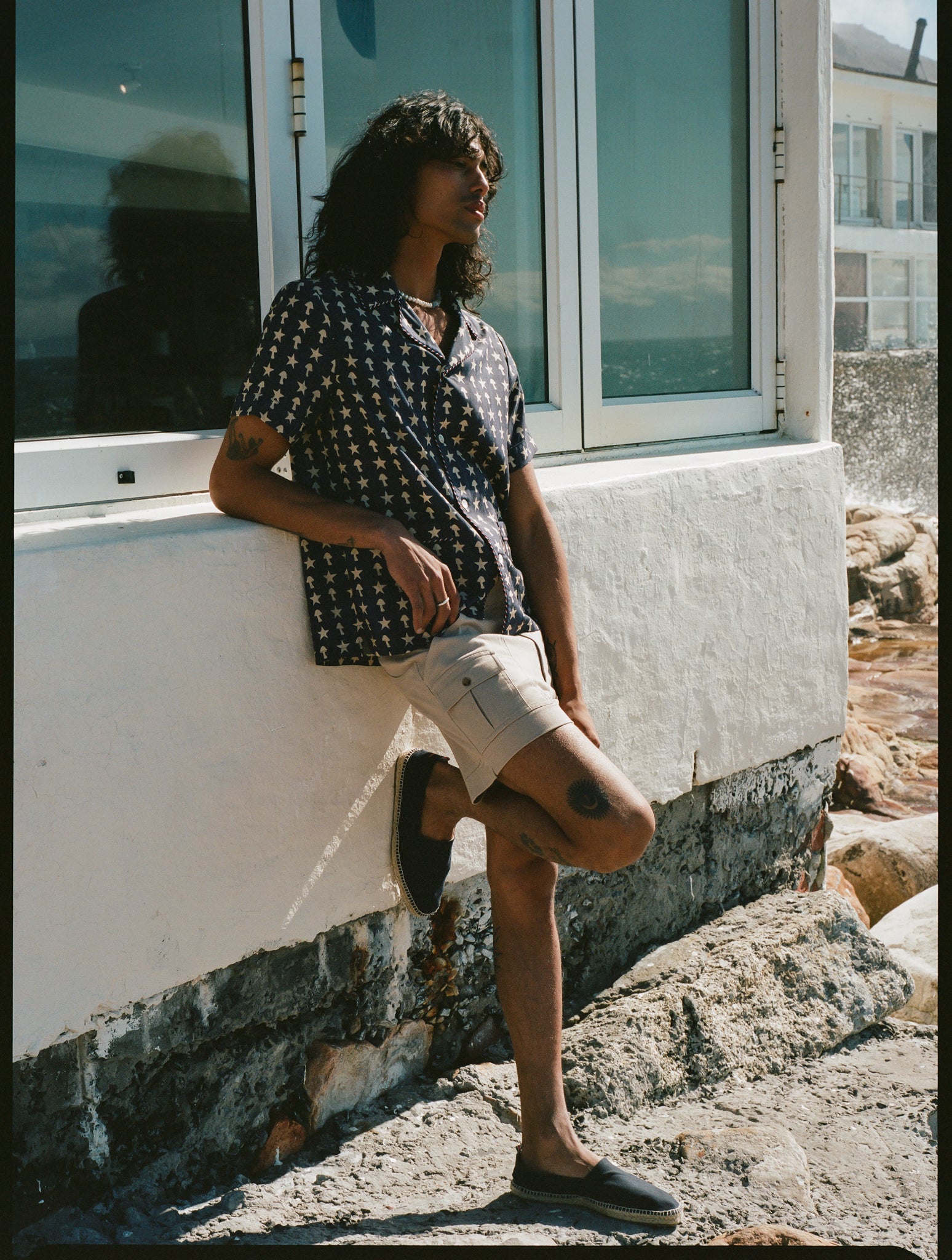 man leans against wall with one foot up