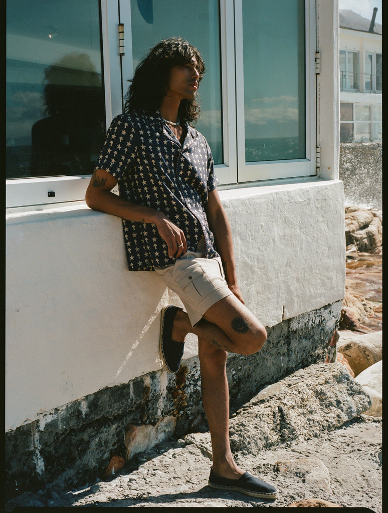 man leans against wall with one foot up