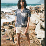 Male model wearing shirt with stowaway shorts on beach