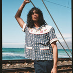 man holds onto rope next to railroad track