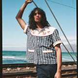 man holds onto rope next to railroad track