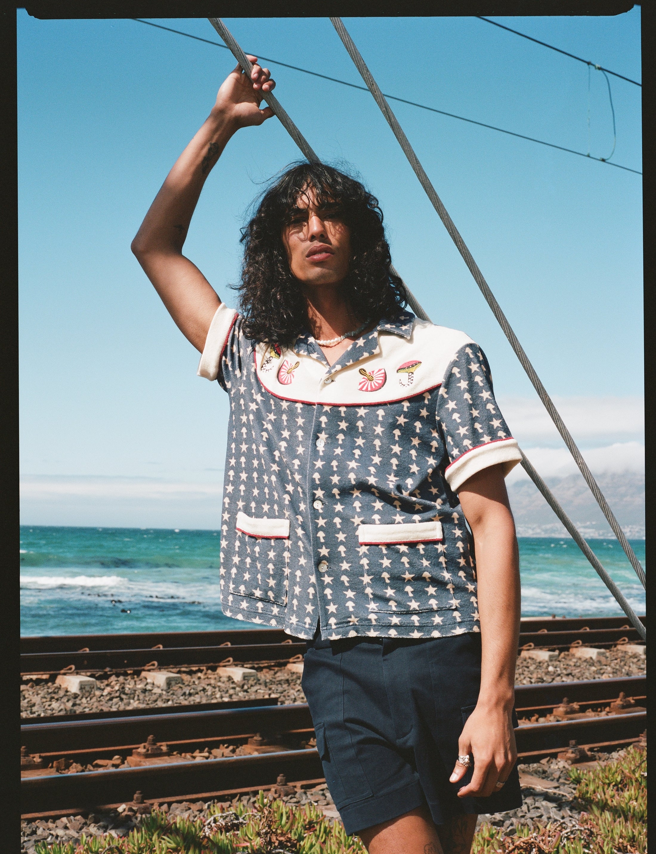 man holds onto rope next to railroad track