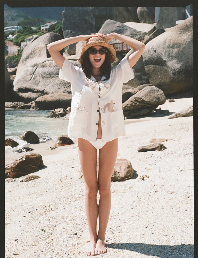 Female model standing in sand wearing shirt