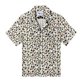 Front view of the sunny disposition hawaiian tee, with a pattern of an abstract field of daisies as well as four brown buttons down the front and blue piping on the collar and front pocket 