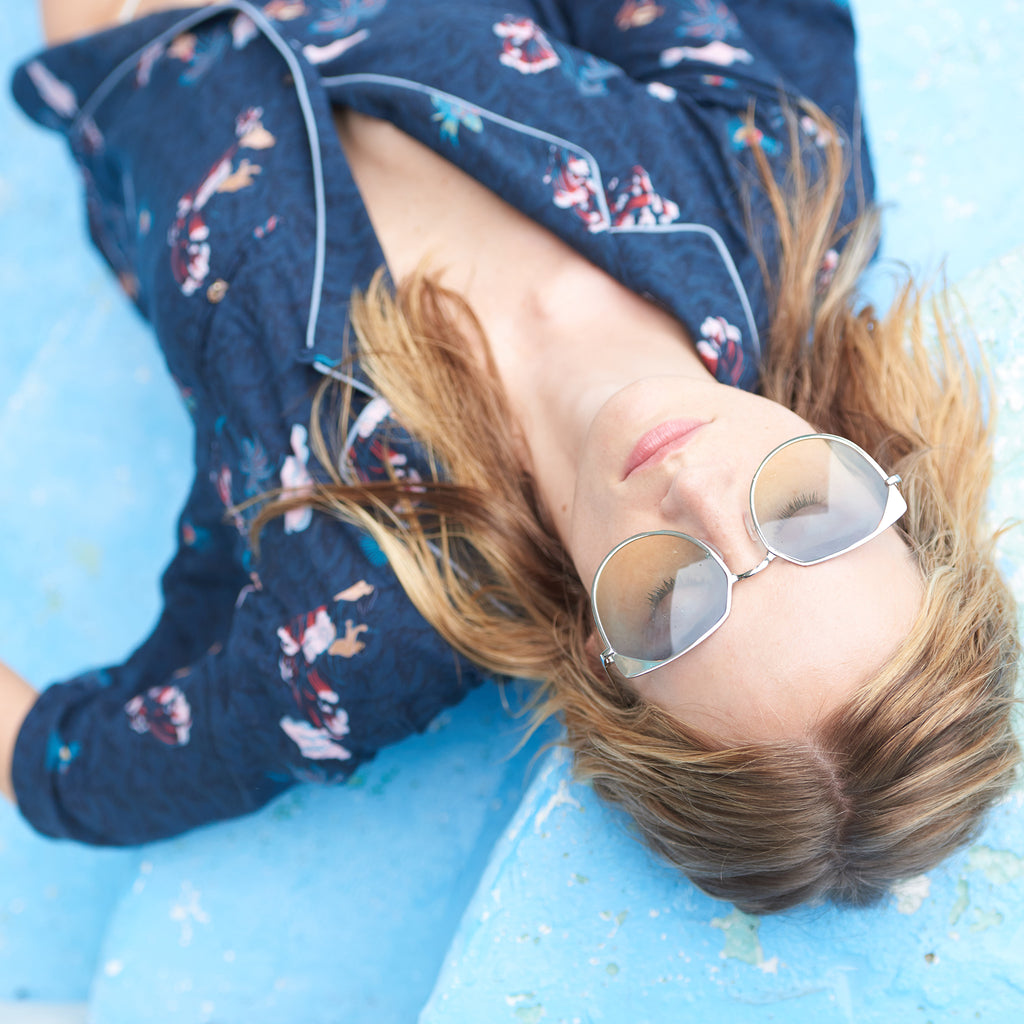 Female model lounging in top wearing sunglasses