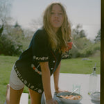 Female model leaning over a bowl of spaghetti wearing the vongole crop