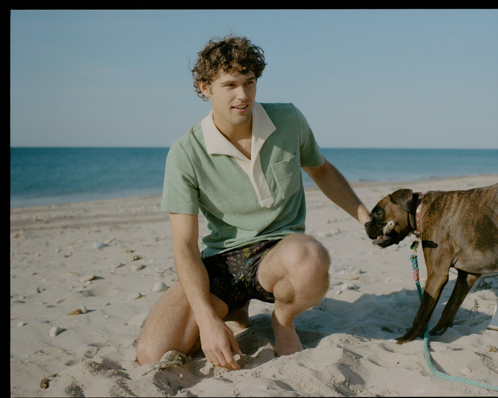 Wide angle shot of man in polo petting dog