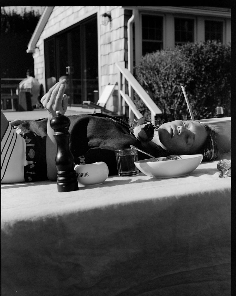 Female model laying on a table outdoors in the vongole crop, photo in black and white