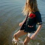 Female model splashing in the sea wearing her vongole crop cut