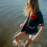 Female model splashing in the sea wearing her vongole crop cut