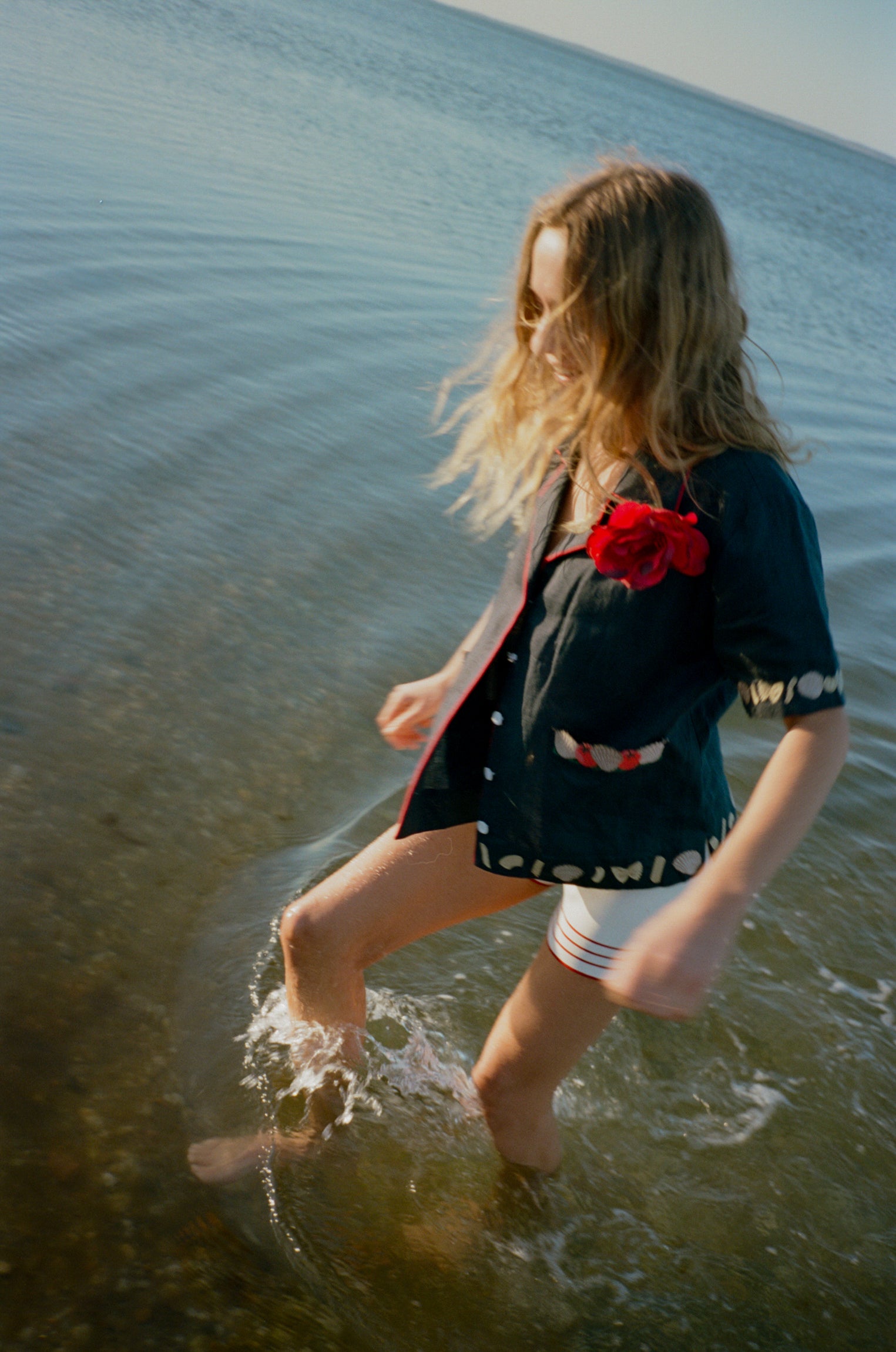 Female model splashing in the sea wearing her vongole crop cut