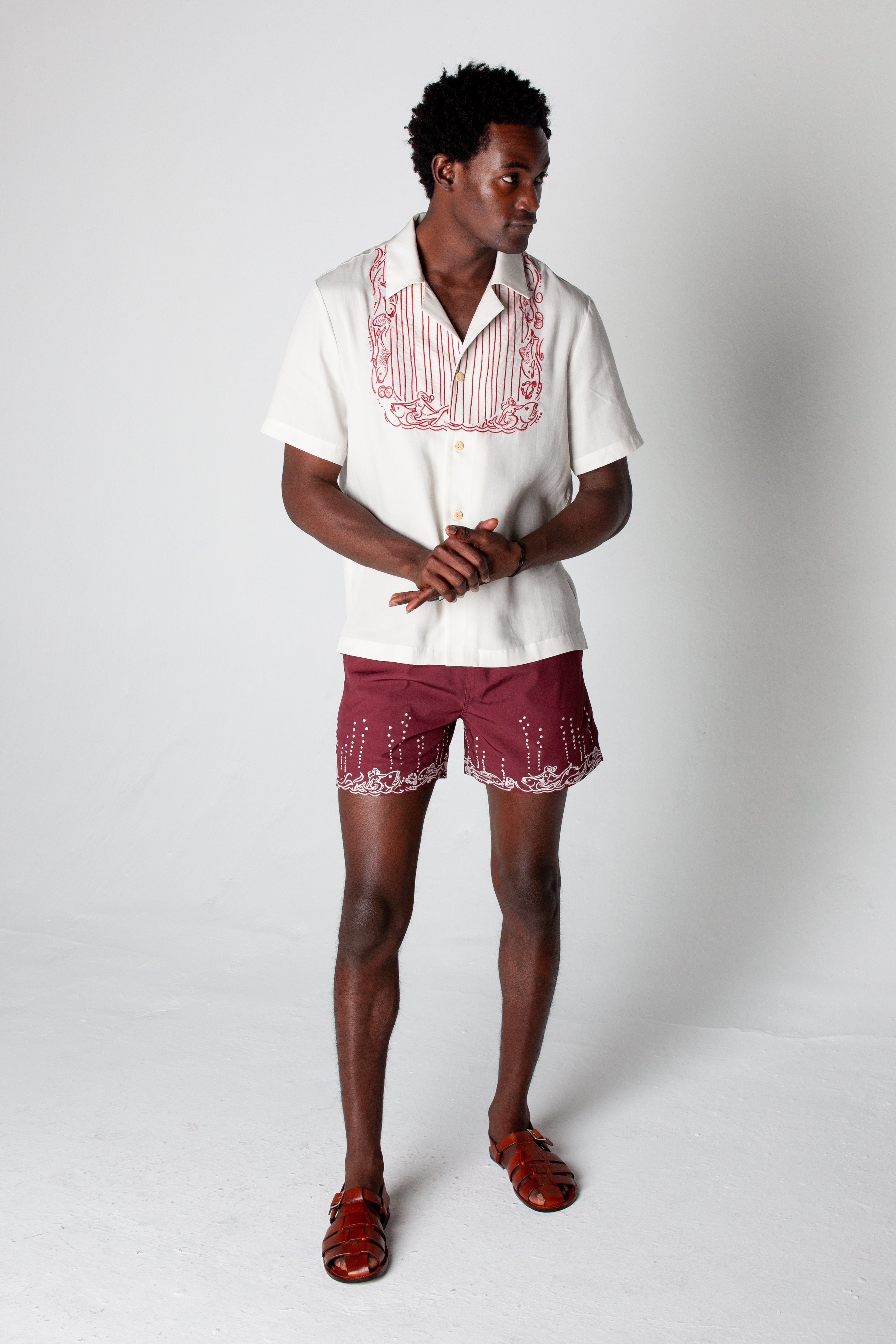 Male model wearing matching set looking right and clasping hands