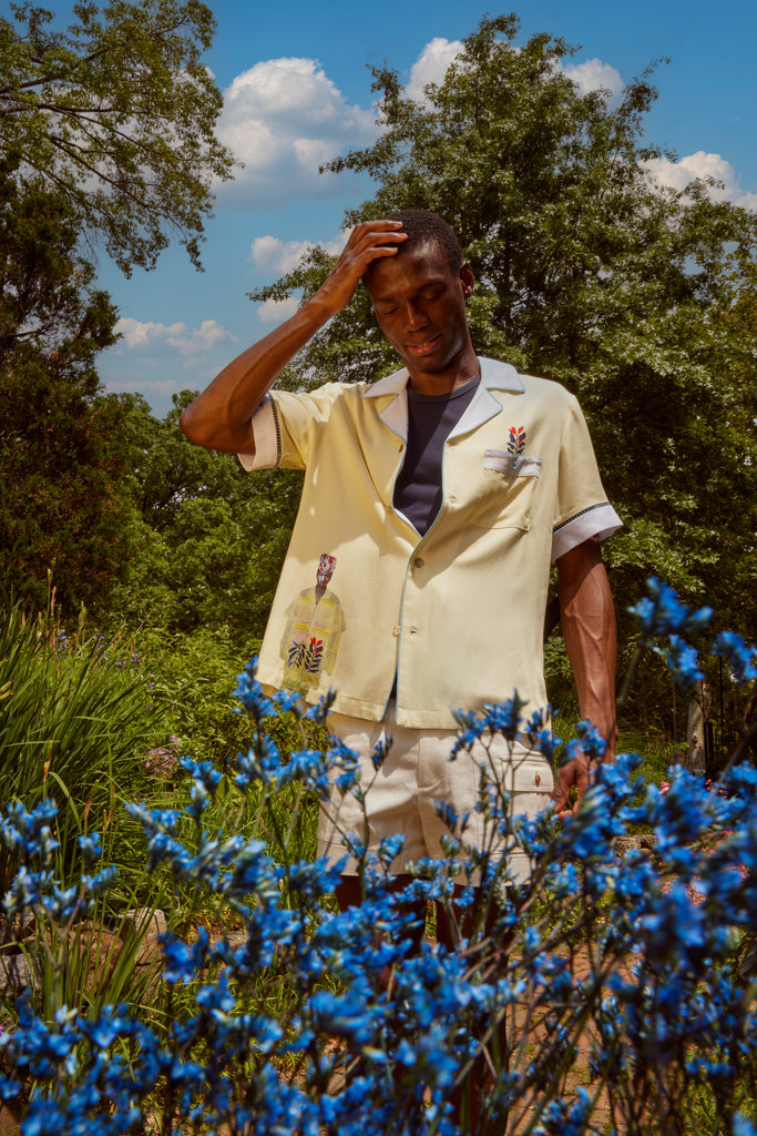 Man stands looking down at blue flowers