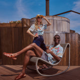 Female model standing in the shirt and male model lounging on a chair in the shirt