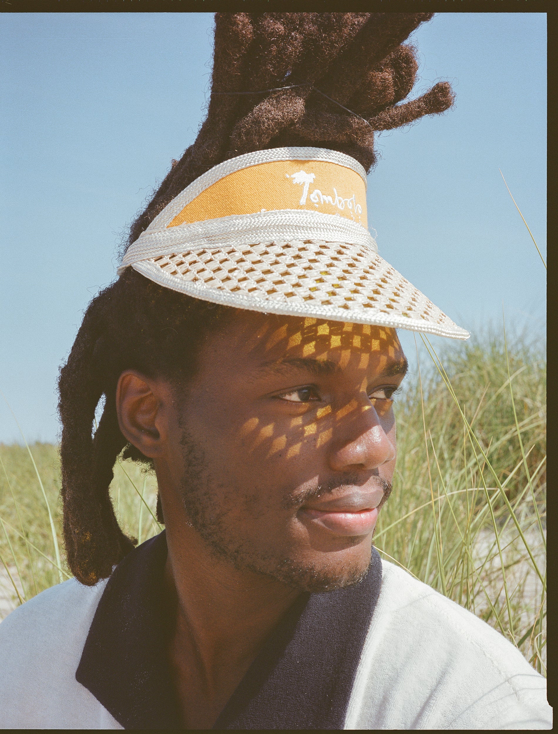 male model in the sun looking right wearing visor