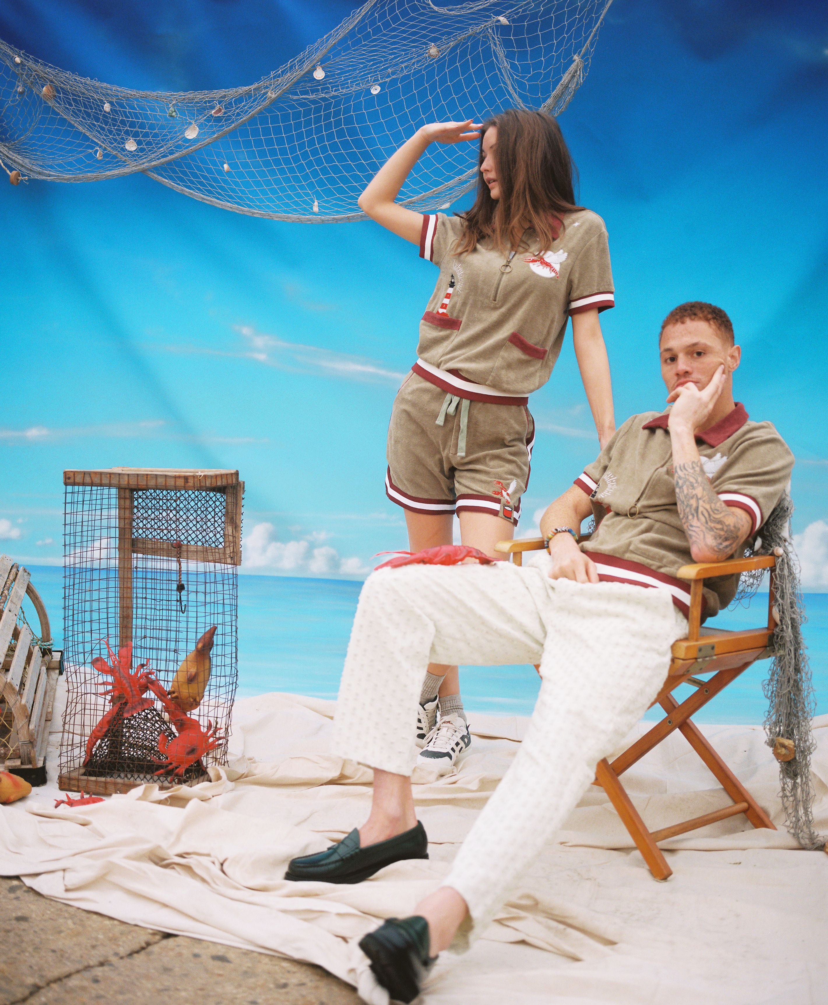 male and female models posing in shell or high water cabana and shorts on a studio made beach scene