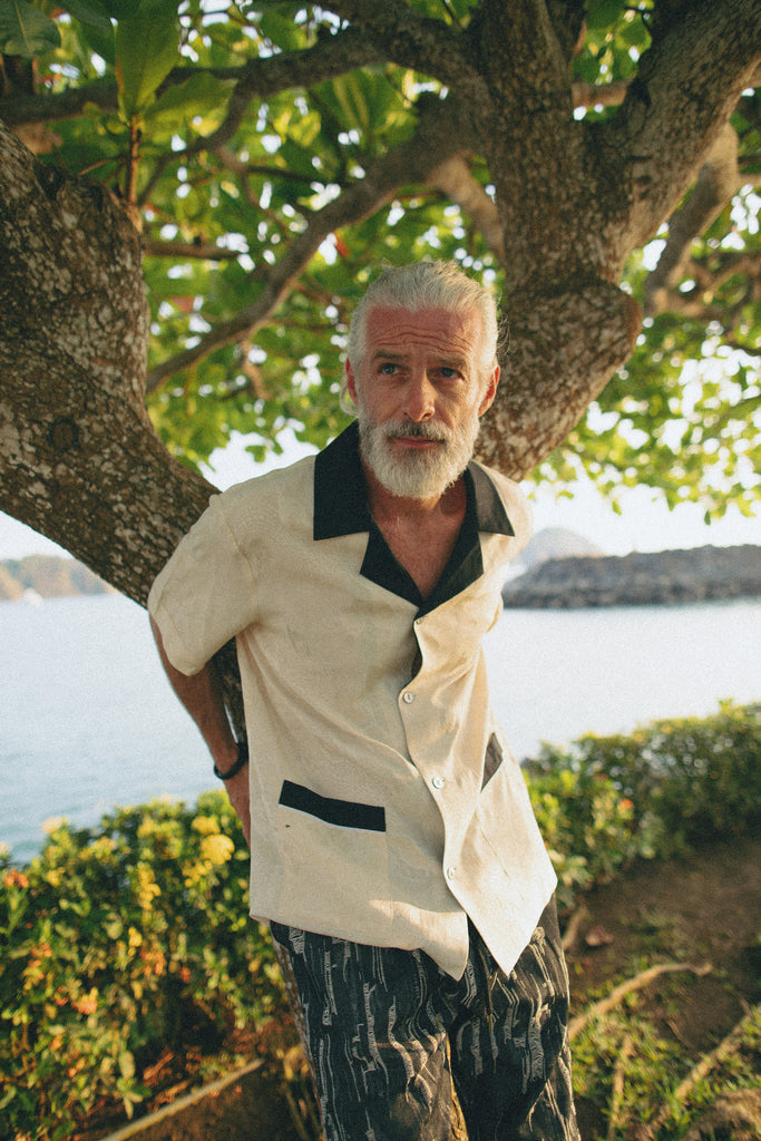 Older male model wearing the cabana while leaning on a tree