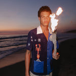 Male model wearing shirt holding a burning stick on the beach