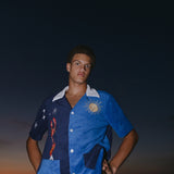 Male model looking down at camera at sunset wearing top