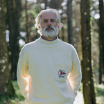 Man stands in forest looking straight at camera