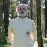 Man stands in forest looking straight at camera