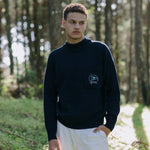 Man stands in forest looking off camera
