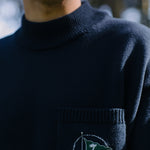 Close up of man wearing sweater with green flag