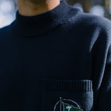 Close up of man wearing sweater with green flag