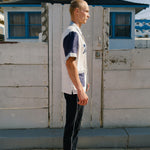 Side view of pants on male model, showing white stripe down side