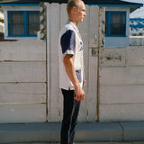 Side view of pants on male model, showing white stripe down side