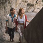 Male model wearing pop over next to female model walking up stairs