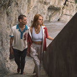 Male model wearing pop over next to female model walking up stairs