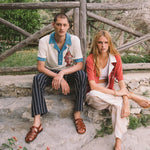 Male model wearing pop over next to a female model sitting down 