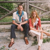 Male model wearing pop over next to a female model sitting down 