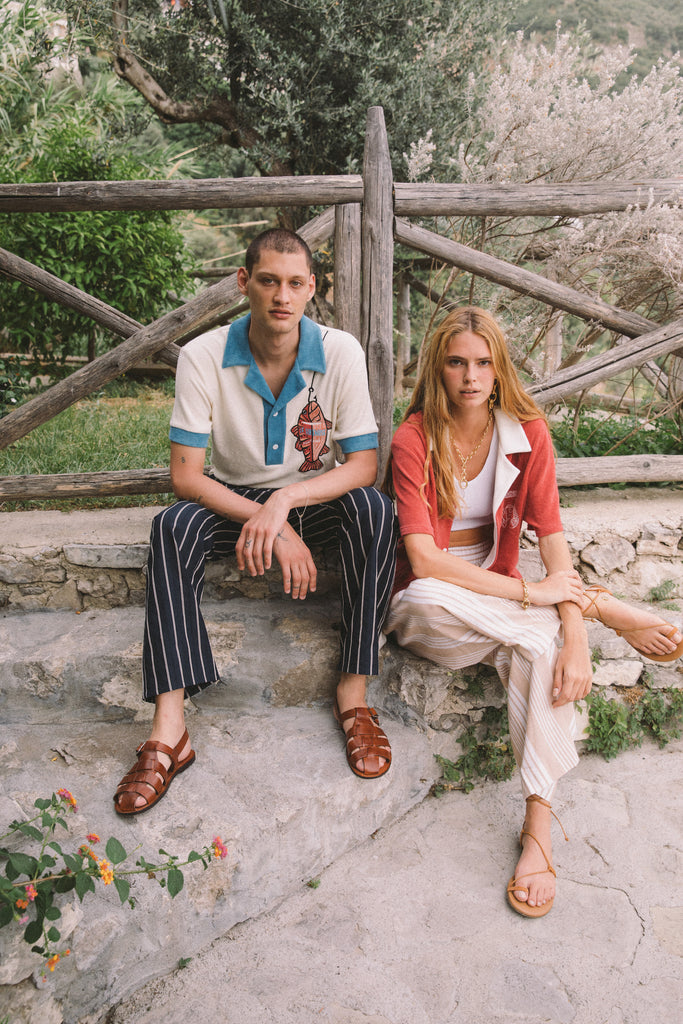 Male model wearing pop over next to a female model sitting down 