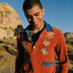 male model with hands in pockets wearing long sleeve disco mushroom terry cloth polo beach shirt