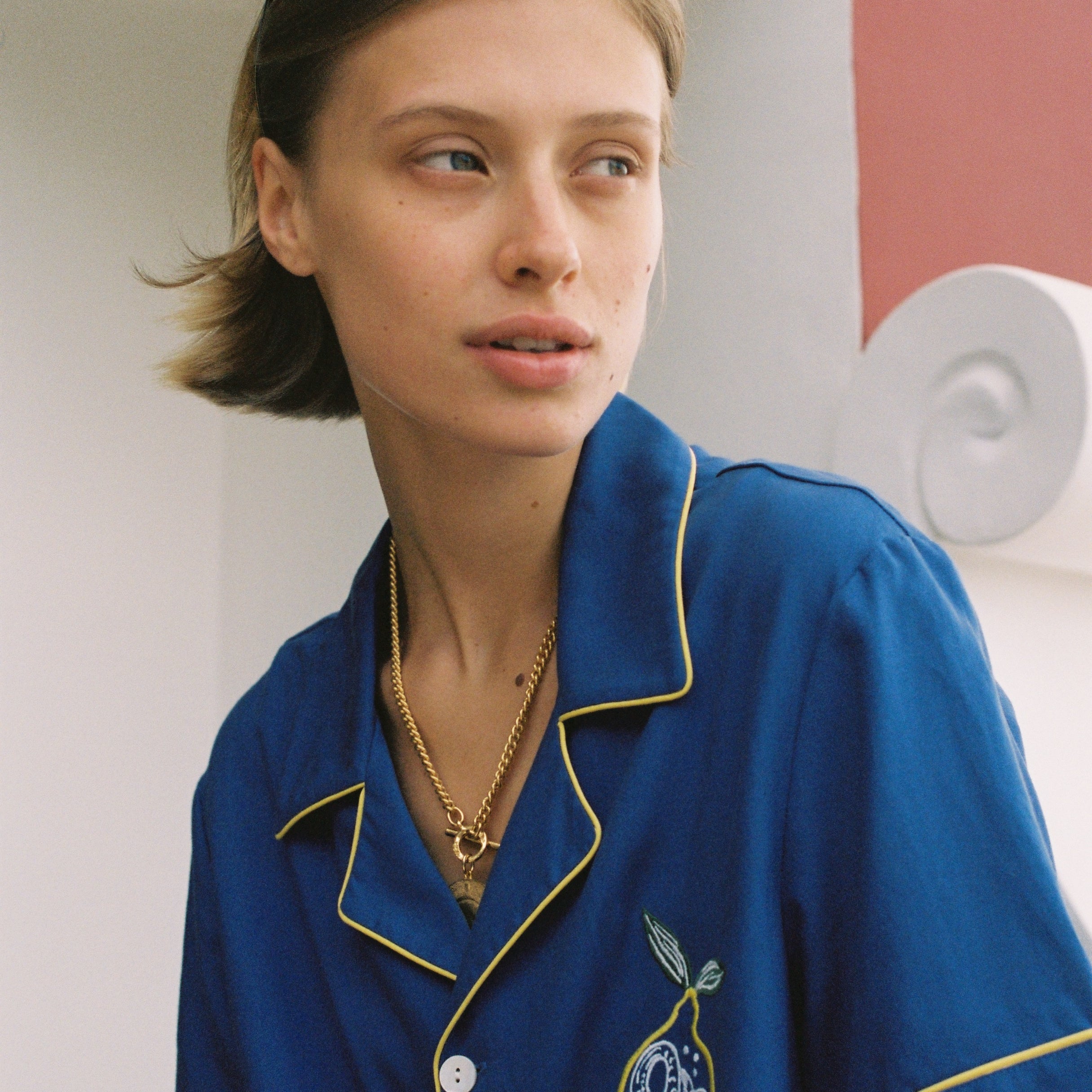 female model in buttoned limoncello top looking over right shoulder