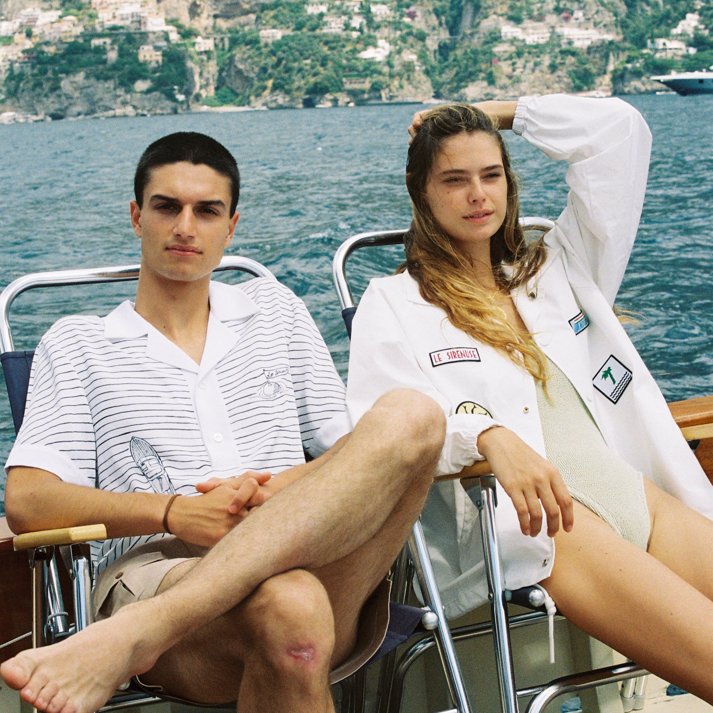 man and woman sit in chairs on boat