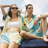 Male and female model both wearing full limoncello set sitting next to each other on boat